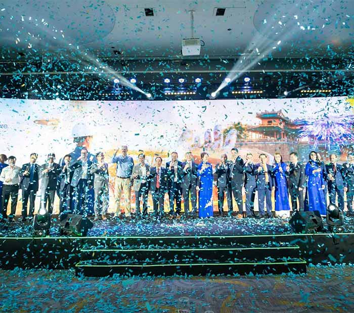 A group of people on stage celebrating with confetti in the air