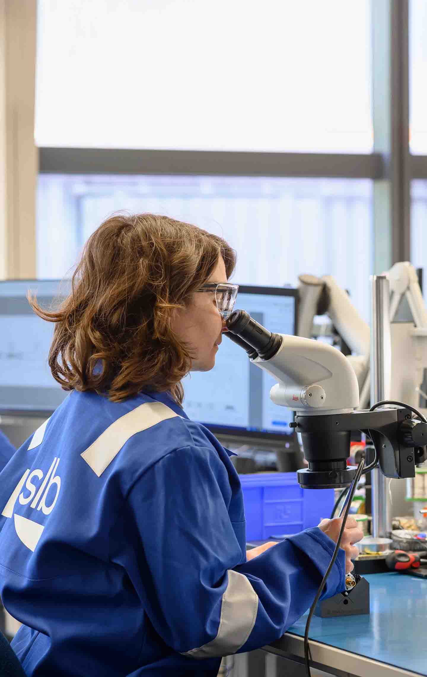 An SLB employee looking through a microscope