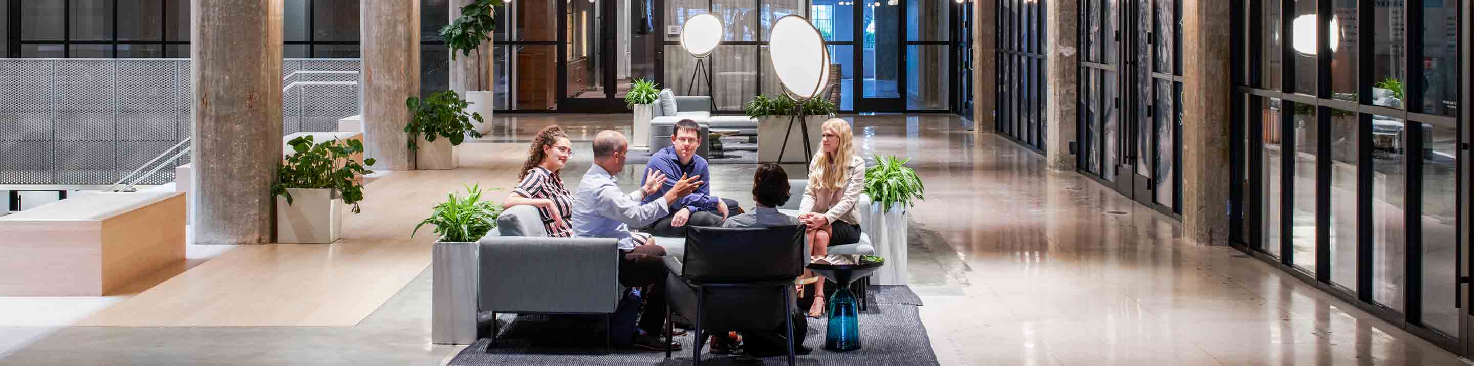 A group of people conversing in an office setting