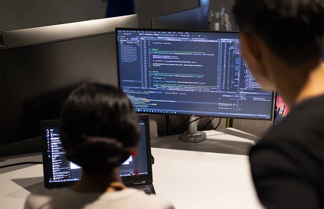 Two people reviewing data on a computer screen
