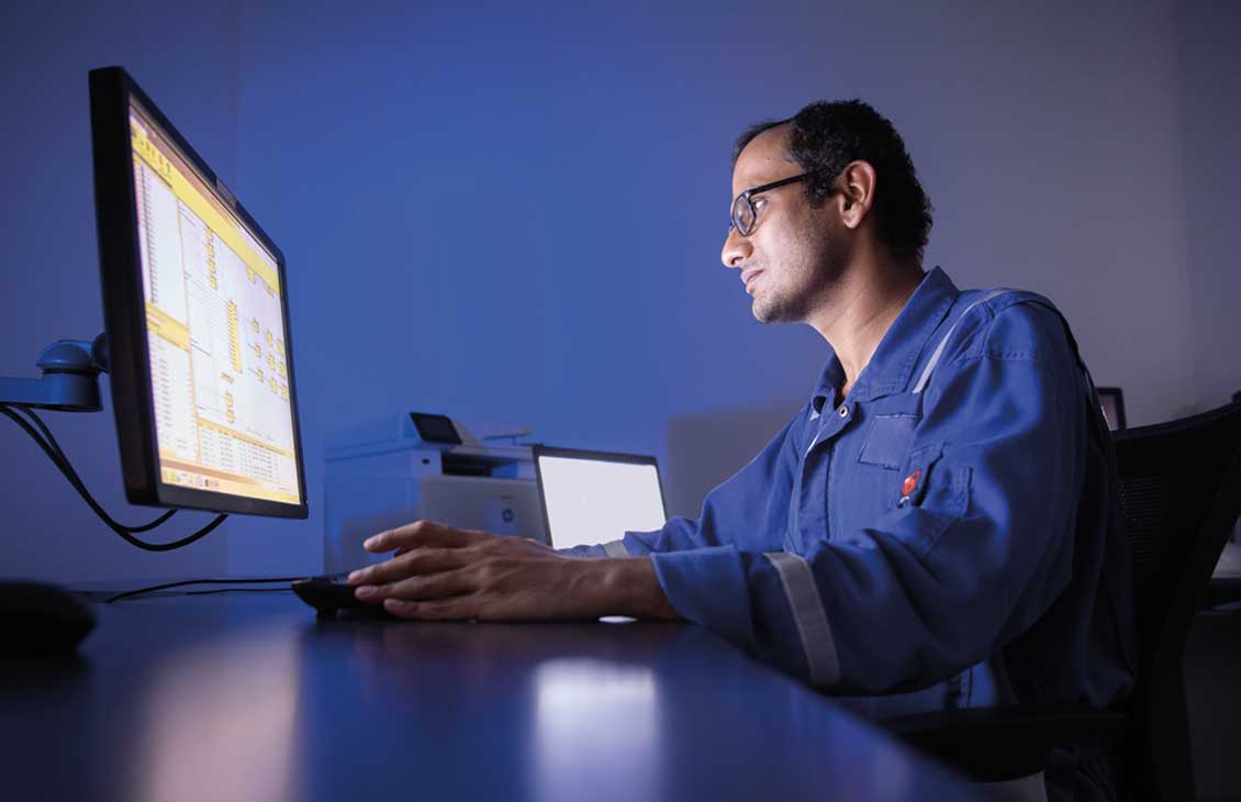 Operator sitting at a desk, looking at a computer monitor.