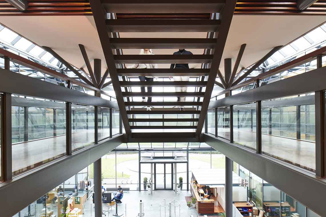 Photo peeking through back of open staircase in office building, two people walking up stairs