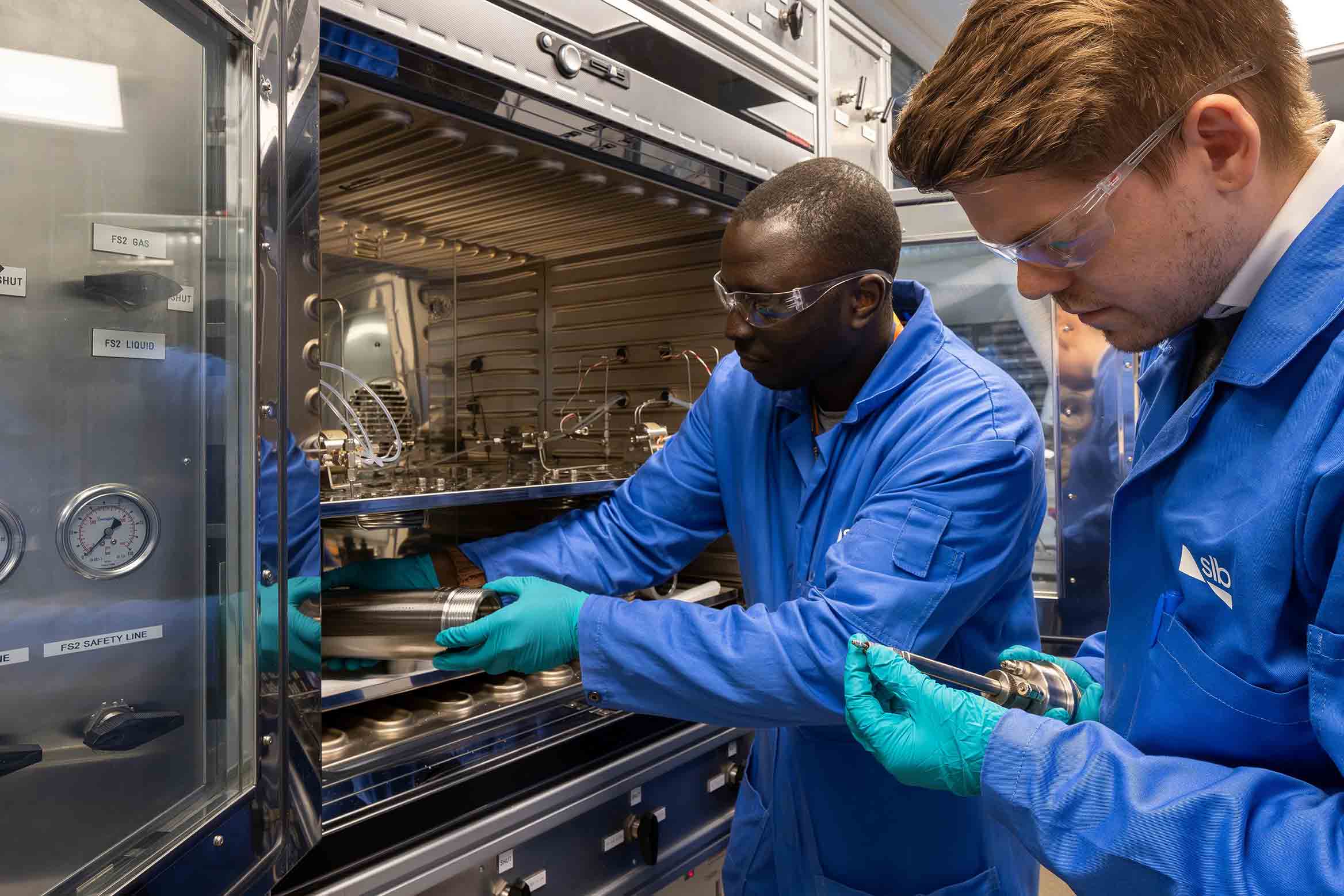 Image of two SLB technicians working in a production chemistry laboratory.
