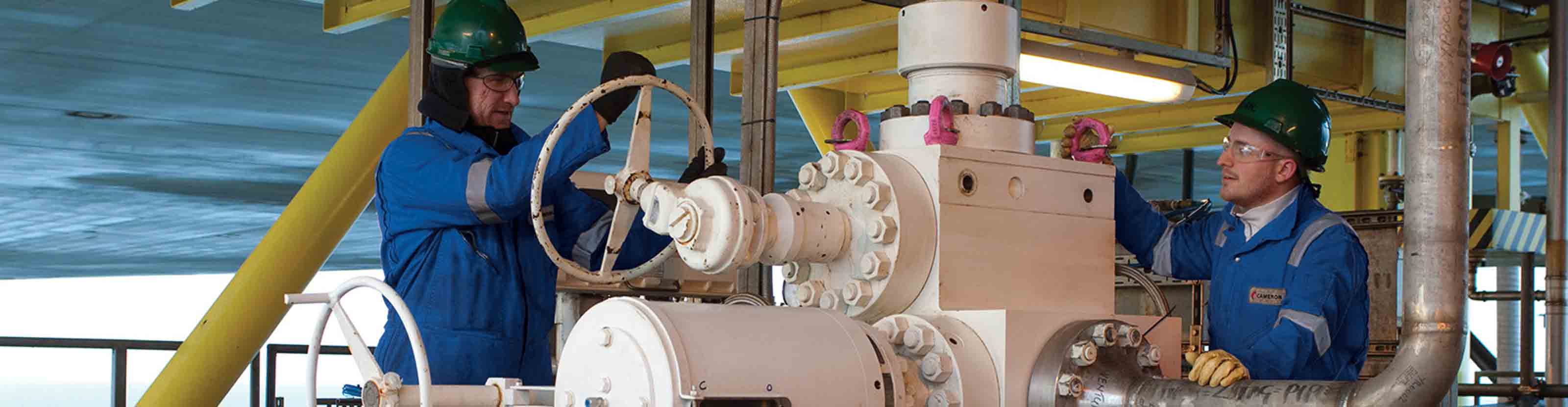 Two men operating a valve.